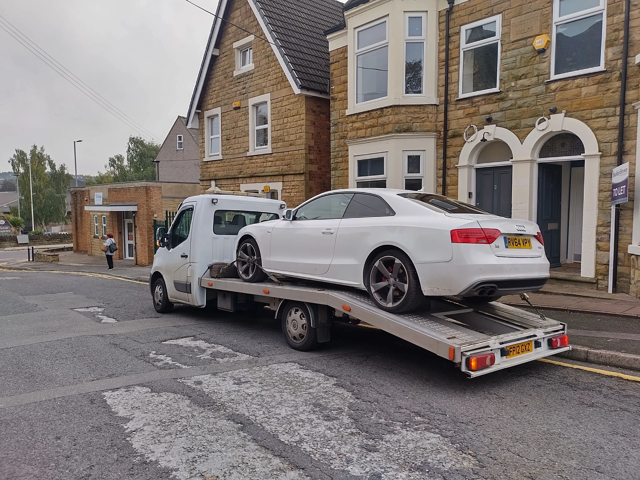 White Audi being recovered on flatbed truck